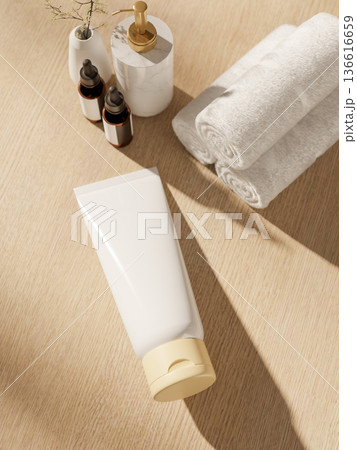 Blank label lotion tube with towel and diffuser on wooden table in bright sunlight at spa bathroom. Blank label lotion tube with towel and diffuser on wooden table in bright sunlight at spa bathroom. 136616659
