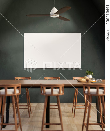 Wooden dining table and stool chairs across blank frame or monitor screen on dark green wall in room 136616661