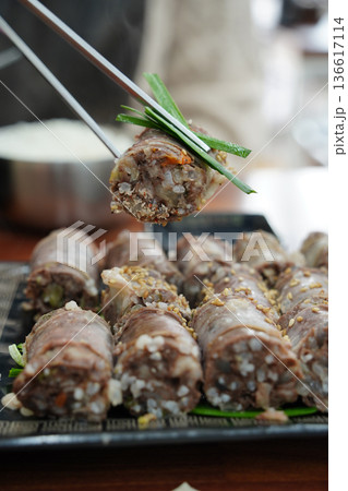Close up of Sliced Korean Blood Sausage Sundae Garnished with Sesame Seeds and Green Onions 136617114