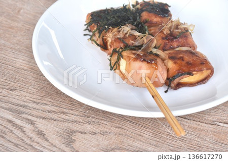 grilled white tofu wrapped pork bacon stabbing in wooden stick topping dry seaweed and fish dressing soy sauce on plate 136617270