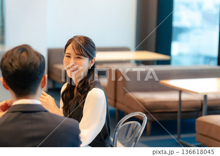 ロビーで笑顔で会話するカップル 136618045