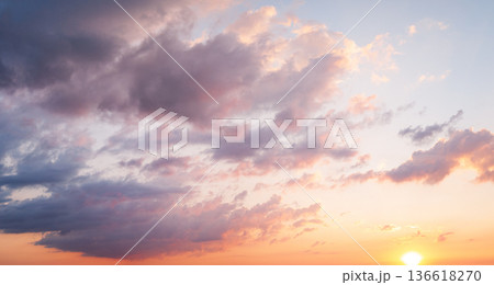 Dramatic clouds with sun rays breaking through sunset sky 136618270