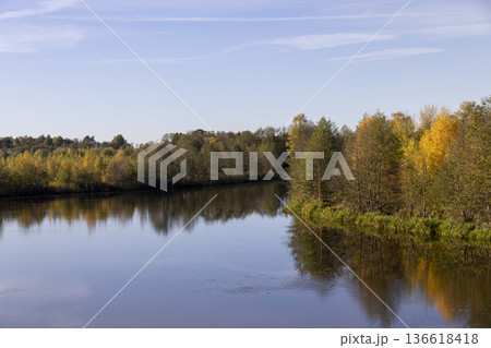 autumn river at sunset, beautiful deciduous trees on the riverbank before the fall of leaves, evening time before sunset autumn river at sunset, beautiful deciduous trees on the riverbank before the fall of leaves, evening time before sunset 136618418