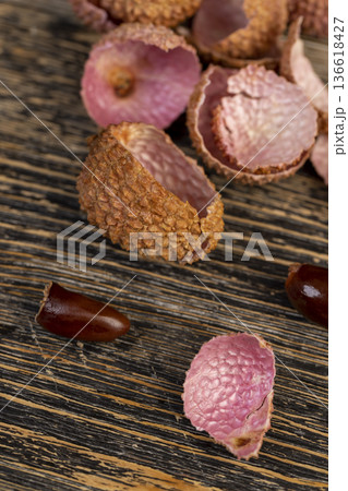 open red lychees cut into pieces on a wooden table, lychee fruits with cut pink tough peel, cooking lychee, close up open red lychees cut into pieces on a wooden table, lychee fruits with cut pink tough peel, cooking lychee, close up 136618427