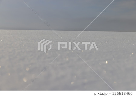 large fresh snowdrifts of white color in the field during the winter season, large soft snowdrifts after large snowfalls in sunny weather, snow structure against the blue sky 136618466