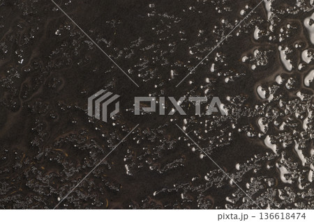 wet black uneven and embossed black slate for serving, covered with lots of water drops kitchen board made of embossed slate, closeup 136618474