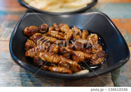 Traditional Korean Street Food Beondegi Boiled Silkworm Pupae in a Black Bowl Traditional Korean Street Food Beondegi Boiled Silkworm Pupae in a Black Bowl 136618586