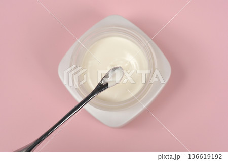 Face cream in a jar with cosmetic spatula on pink background top view Face cream in a jar with cosmetic spatula on pink background top view 136619192