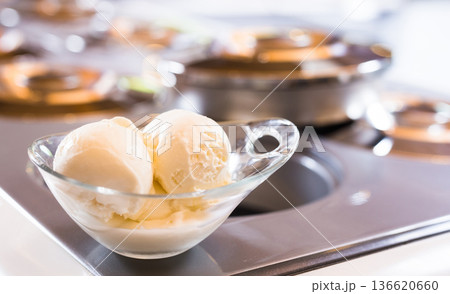 glass dessert bowl with vanilla ice cream on the table in the display case for distribution 136620660