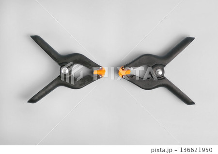 Two Black Spring Clamps Facing Each Other Isolated on White Two Black Spring Clamps Facing Each Other Isolated on White 136621950