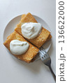 Two crepes filled with yogurt are placed on a white plate. A fork sits beside the plate. The setting suggests a simple breakfast time in a kitchen 136622000