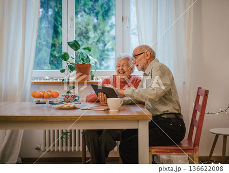 Senior coule working with tablet, making reservation or shopping online. 136622008