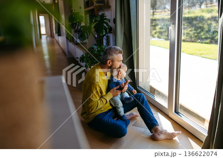 Father with little toddler son looking out of window. 136622074
