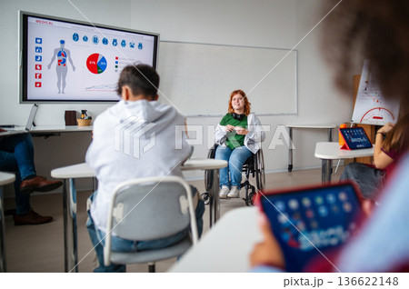 High school student in wheelchair leading classroom discussion. 136622148