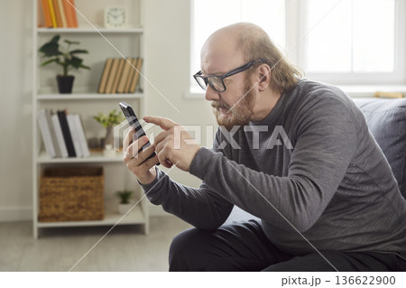 Senior with smartphone, old father learning how to use app, choose goods or services via internet Senior with smartphone, old father learning how to use app, choose goods or services via internet 136622900