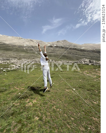 A man makes a jump against a mountain landscape. High quality photo 136623154