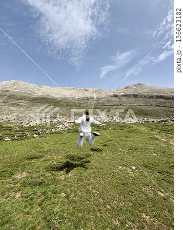 A man makes a jump against a mountain landscape. High quality photo 136623182