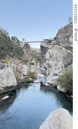 A red metal bridge over a mountain river. High quality photo 136623259