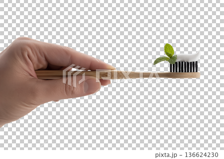 Hand holding a sustainable bamboo toothbrush with green mint toothpaste applied, representing eco-friendly oral care and zero waste living Hand holding a sustainable bamboo toothbrush with green mint toothpaste applied, representing eco-friendly oral care and zero waste living 136624230
