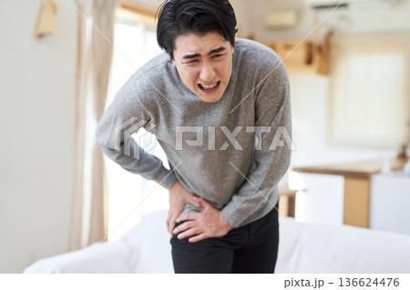 股関節が痛くて苦しむアジア人男性 136624476