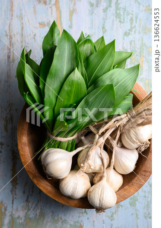 Bunch of wild garlic with garlic bulbs on light wooden background 136624553