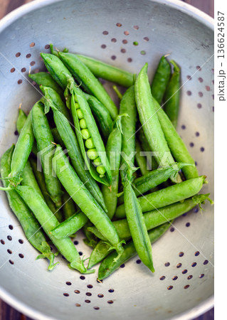 Fresh green peas in metal colander ready for washing Fresh green peas in metal colander ready for washing 136624587