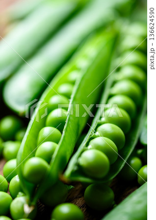Fresh green peas in wooden bowl close up Fresh green peas in wooden bowl close up 136624590