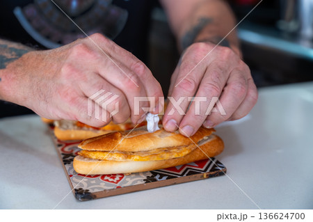 Hands preparing spanish tortilla sandwich with toothpick 136624700