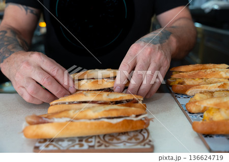 Person's hands preparing various spanish bocadillos 136624719