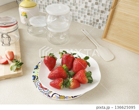 Composition of fresh strawberries and empty jars in kitchen. Seasonal farm produce and homemade preserves. Design backdrop. Composition of fresh strawberries and empty jars in kitchen. Seasonal farm produce and homemade preserves. Design backdrop. 136625095