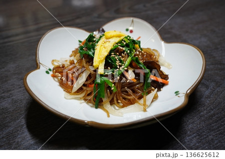 Traditional Korean Japchae, Stir-fried Glass Noodles with Mixed Vegetables, Spinach, Carrots, and Egg Garnish 136625612