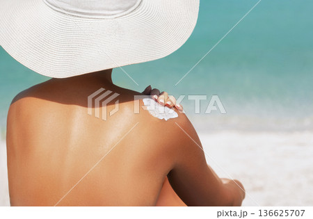 Woman applying sunscreen creme on tanned shoulder. Skincare. Body Sun protection suncream. Bikini hat woman applying moisturizing sunscreen lotion on back. Woman applying sunscreen creme on tanned shoulder. Skincare. Body Sun protection suncream. Bikini hat woman applying moisturizing sunscreen lotion on back. 136625707