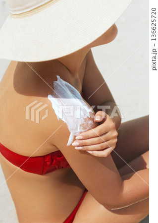 Sunscreen woman. Woman applying sunscreen on tanned skin Sunscreen woman. Woman applying sunscreen on tanned skin 136625720