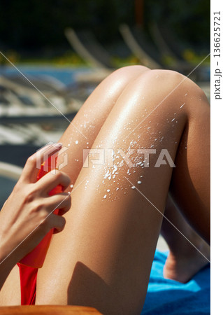 Woman apply sun cream protection cream on her smooth tanned legs. Beautiful legs outdoors by on white sand beach. Woman apply sun cream protection cream on her smooth tanned legs. Beautiful legs outdoors by on white sand beach. 136625721