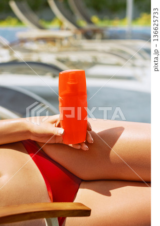 Female hand holding sunscreen cream bottle.Sunbath protection. Female hand holding sunscreen cream bottle.Sunbath protection. 136625733