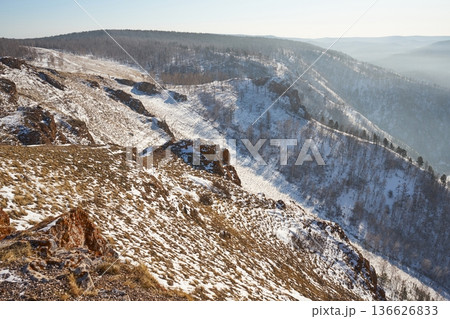 Snow covered mountain slope with dry grass and sparse forest at winter. Scenic landscape for nature, travel and season publication. Torgashinsky ridge, Krasnoyarsk, Siberia. Snow covered mountain slope with dry grass and sparse forest at winter. Scenic landscape for nature, travel and season publication. Torgashinsky ridge, Krasnoyarsk, Siberia. 136626833