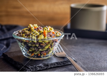 Fresh salad with edamame beans in bowl on black table. Fresh salad with edamame beans in bowl on black table. 136626893
