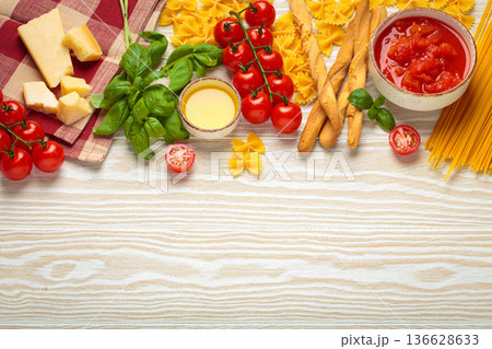 Italian food cuisine background featuring tomato sauce, grissini, pasta, parmesan, fresh basil Italian food cuisine background featuring tomato sauce, grissini, pasta, parmesan, fresh basil 136628633