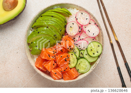 Salmon poke bowl with avocado, radish, cucumber and rice on light beige background top view Salmon poke bowl with avocado, radish, cucumber and rice on light beige background top view 136628646