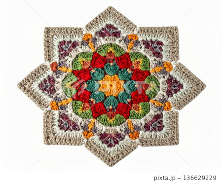 Detailed Crochet Star Motif in Red Green and Beige Against a White Background 136629229