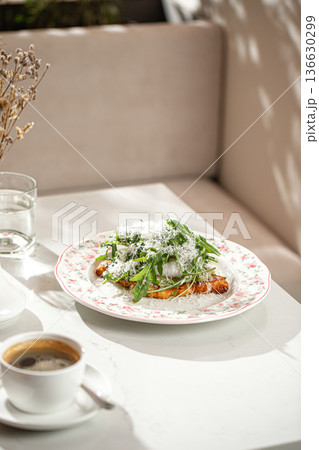 Flat croissant breakfast with poached egg and greens 136630299
