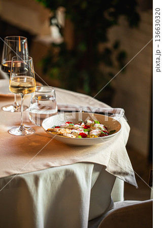 Salad with fish and wine on restaurant table Salad with fish and wine on restaurant table 136630320