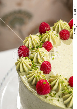 Pistachio raspberry cake on glass stand Pistachio raspberry cake on glass stand 136630332