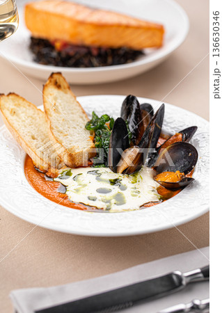 Mussels soup and salmon with wild rice Mussels soup and salmon with wild rice 136630346