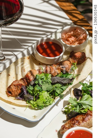 Caucasian lamb shashlik with red sauce and onions 136630348