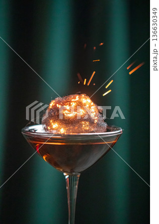 Cocktail with burning cotton candy garnish 136630349