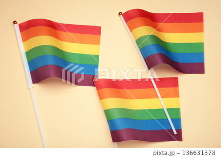 LGBT rainbow flag flat lay on beige background. Human rights, gay marriage, june parade, lgbtq proud history month concept, coming out day. top view, place for logo or text LGBT rainbow flag flat lay on beige background. Human rights, gay marriage, june parade, lgbtq proud history month concept, coming out day. top view, place for logo or text 136631378