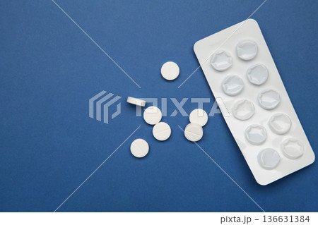 Empty medicine blister on dark blue background, representing healthcare, medicine, and treatment concepts Empty medicine blister on dark blue background, representing healthcare, medicine, and treatment concepts 136631384