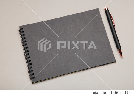 Black notebook with black pen on grey background. Mockup Black notebook with black pen on grey background. Mockup 136631399