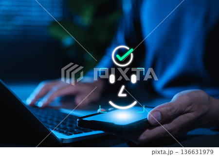 Facial recognition and Face ID biometric authentication concept. User holding smartphone, face scan icon, and check mark, representing cybersecurity, digital identity and secure mobile access. 136631979